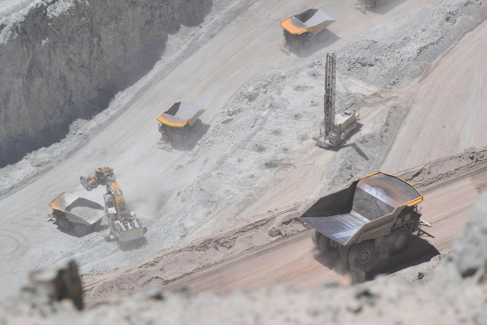 Mining trucks and drilling equipment at an open-pit mine in Chile